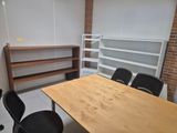 a room with a table, chairs, shelves and a bookcase