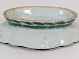 a green and white bowl sitting on top of a saucer