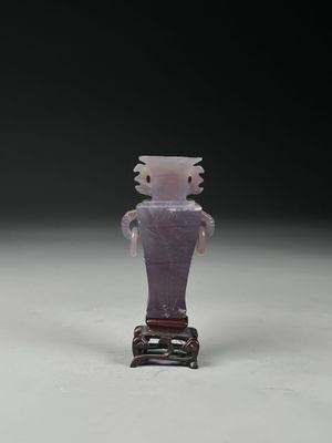 une petite figurine représentant un homme vêtu d'une chemise violette