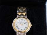 a gold and silver watch in a black box