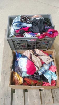 two boxes with clothes in them on a wooden table