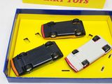 three toy cars in a box on a table