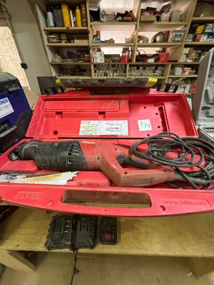 une boîte à outils rouge contenant des outils, posée sur un établi