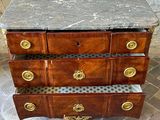 a marble top chest of drawers on a brick floor