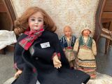 two dolls that are sitting on a chair in the room