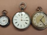 three different types of pocket watches displayed on the wall