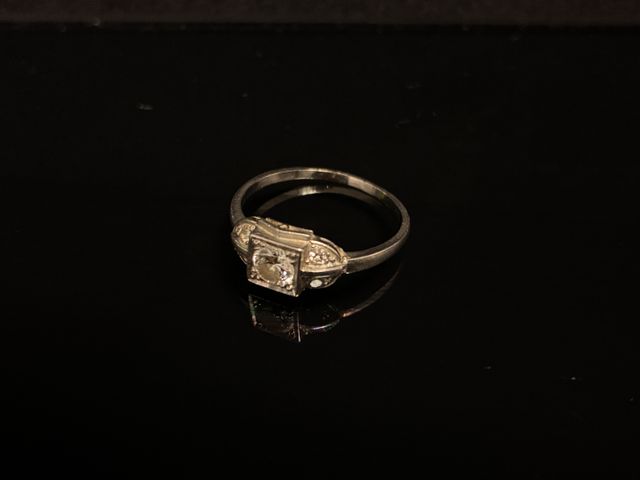 Une bague en or gris à décor centré d’un diamant d’environ 40/100...