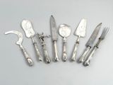 six pieces of silverware are arranged in a row on a table