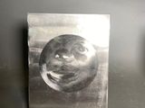 a picture of a picture of a face on a metal plate