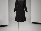 une robe noire posée sur un mannequin dans une pièce blanche