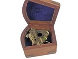 a small wooden box with a brass object inside of it