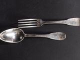 two spoons and a fork on a black table