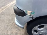 a car that has been badly damaged and is parked on the side of the road