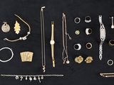 un assortiment de bijoux en or et en argent disposés sur un fond noir