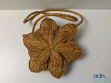 un sac à main marron orné d'une fleur sur un fond blanc