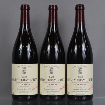 three bottles of wine are lined up on a glass table