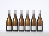 six bottles of wine lined up in a row on a table