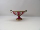 an image of a red and gold bowl on a white surface