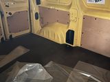 the inside of a van with the door open and the floor covered in plastic