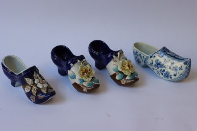 cinq sabots miniatures ornés de fleurs, posés sur un fond blanc