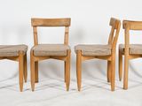 three wooden chairs sitting next to each other on a white surface