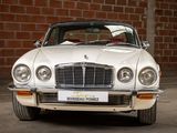 a white car parked in front of a brick wall