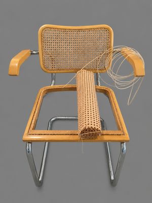 a wicker chair with a wicker seat and a wicker arm rest
