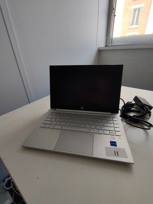 a laptop computer sitting on a table next to a window