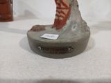 une petite statue représentant une personne assise sur un rocher
