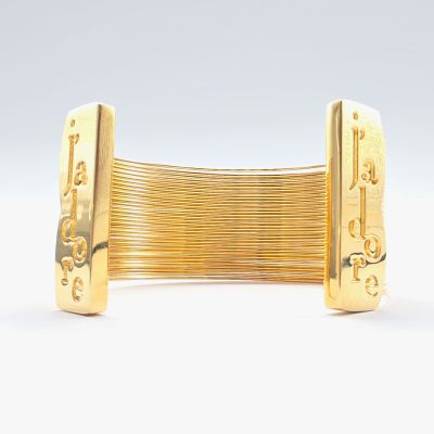 un gros plan d'un bracelet en or sur lequel figure un numéro