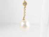a close up of a pair of earrings with pearls hanging from them