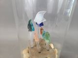 a glass jar with a sand and sea animals inside of it
