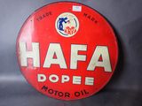 une enseigne rouge et blanche sur laquelle on peut lire « hafa pope motor oil »