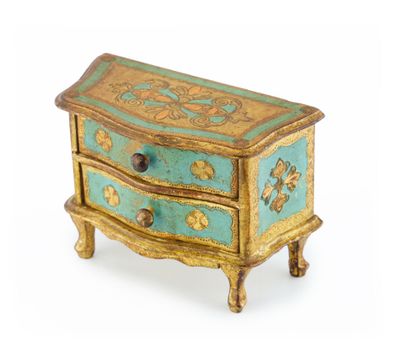 une petite commode bleue et dorée sur fond blanc
