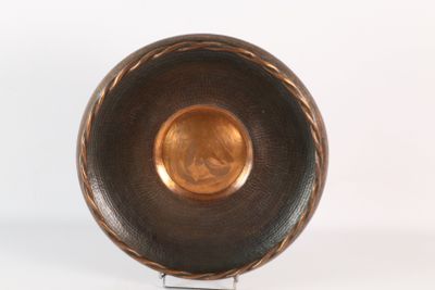 a metal bowl on a metal stand on a white surface