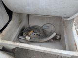 a white tank with a hose in it sitting on the ground