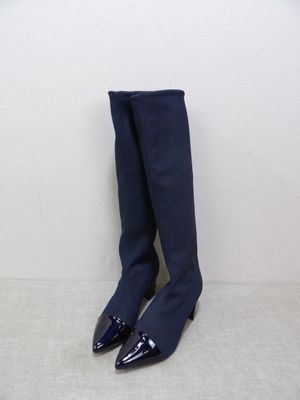 a pair of blue knee high boots sitting on top of a white floor
