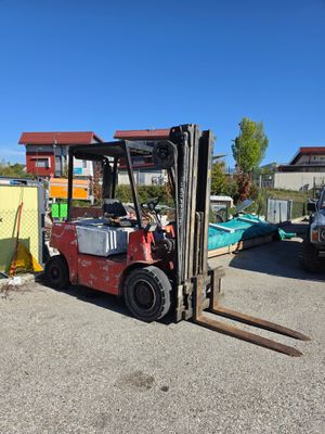 un chariot élévateur garé sur un parking à côté d'autres véhicules