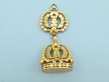 a close up of a gold pendant with a crown on it