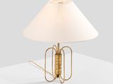 a gold table lamp with a white shade on top of a white table