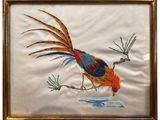 embroidered picture of a bird on a branch in a gold frame