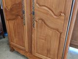 a wooden armoire with a metal handle on it