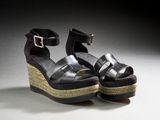 black wedged sandals with a metal buckle on the ankle
