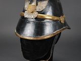 an old black helmet with a gold eagle on top of it