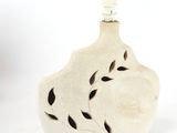 a small white vase with a light on top of it