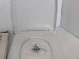 a white toilet with the lid up next to a box of toilet paper