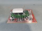 a green toy car with a white top on a card