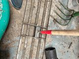a man standing next to a pile of tools on the ground
