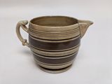 a brown and black striped cup on a white surface
