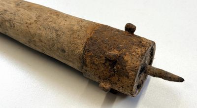 un vieux bâton en bois d'où sort un clou